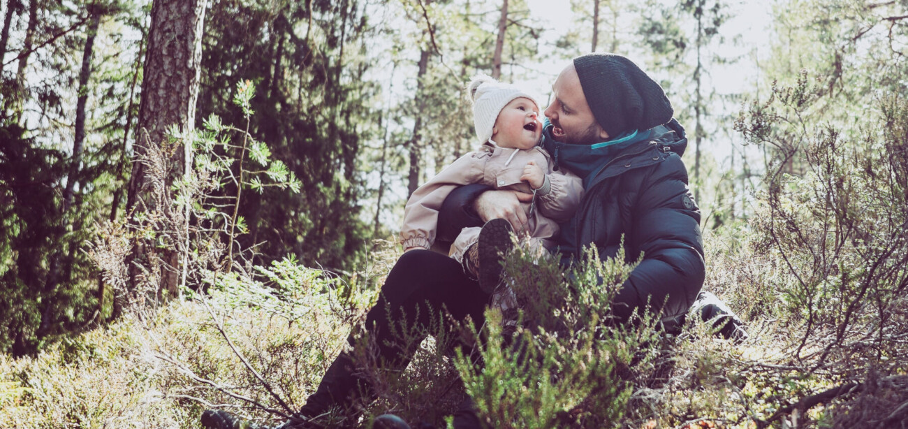 Man og liten jente på tur i skogen