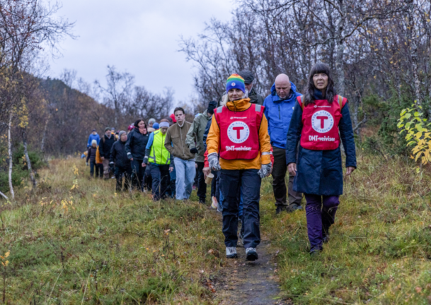 To damer fra DNT leder en folk på stien i Harstad. De går tur i forbindelse med Verdensdagen for psykisk helse.